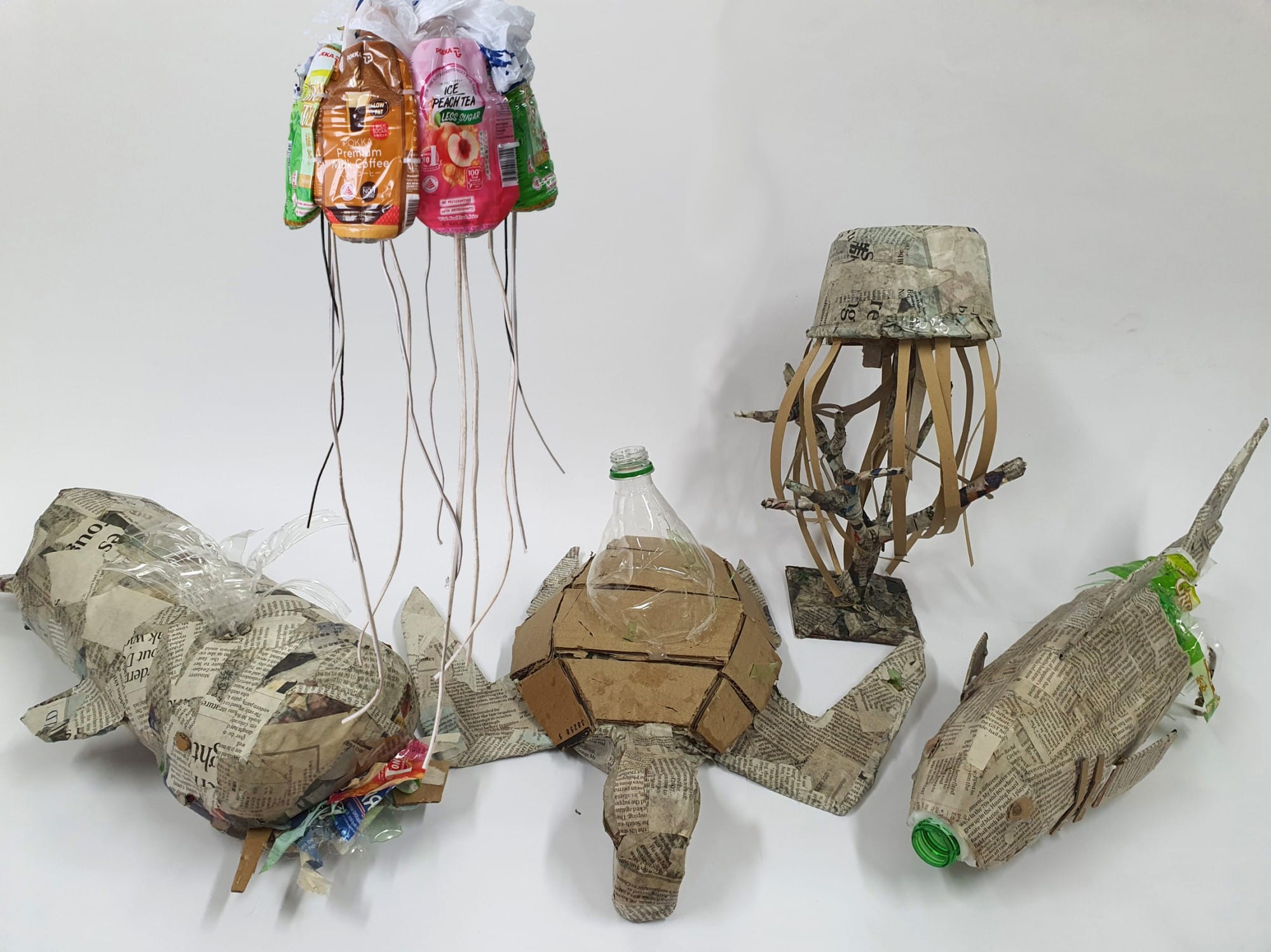 Recycled waste sculptures of sea animals and jellyfish made from newspaper, cardboard, plastic bottles, and food packaging.